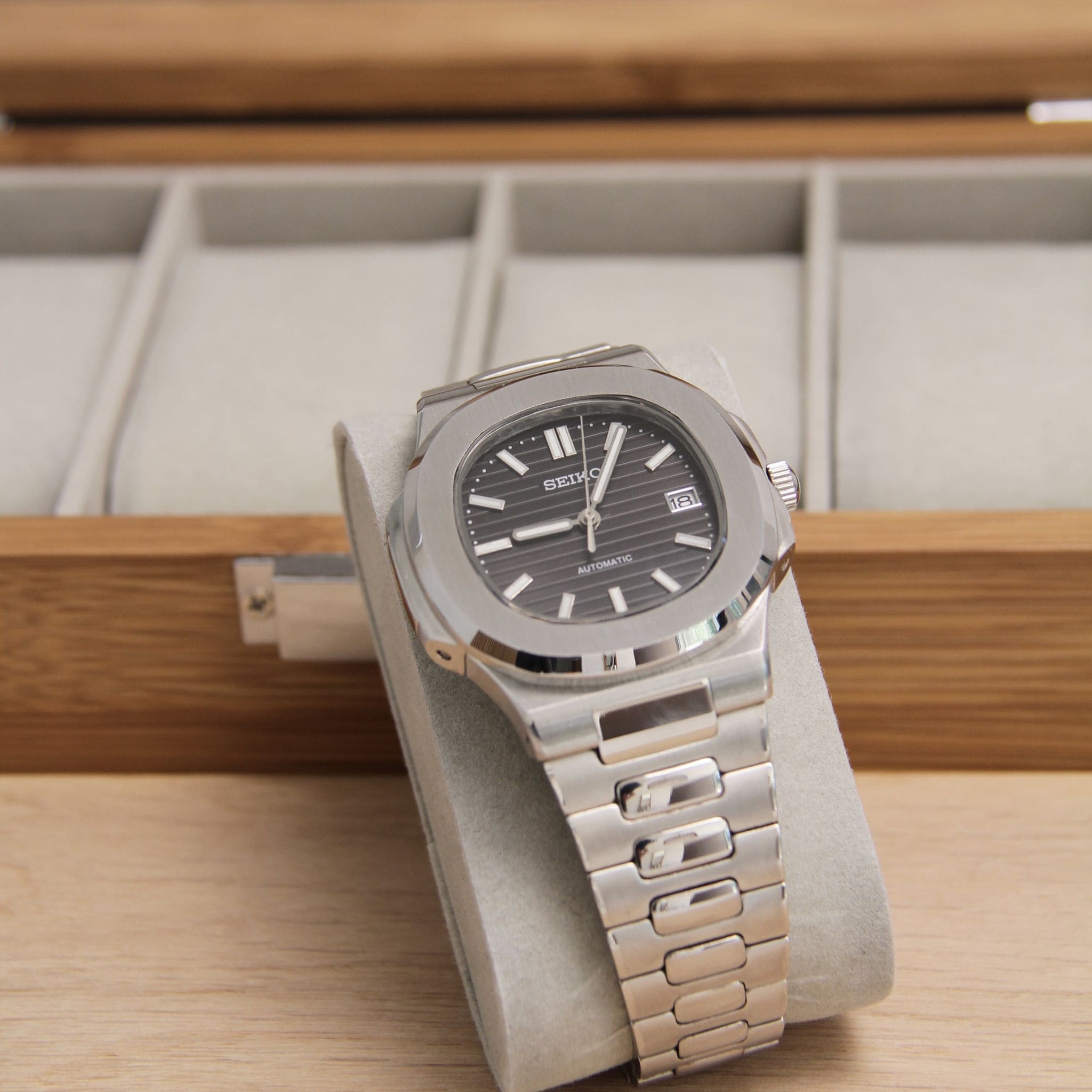 Montre Seiko mod nautilus noir vu de face sur coussin