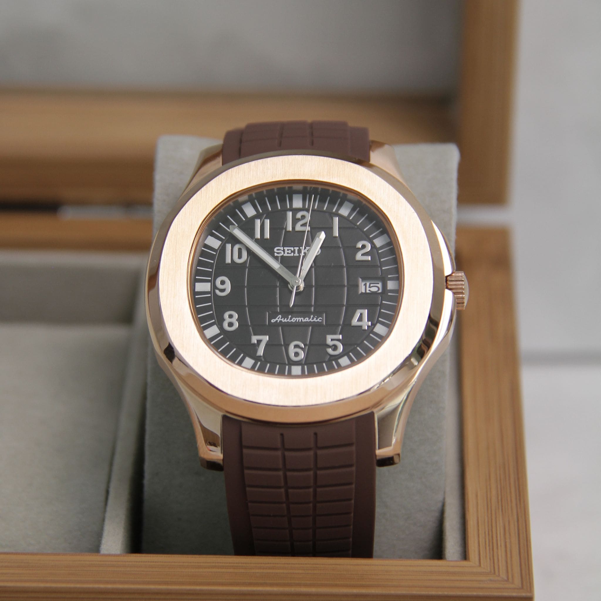 Montre Seiko mod aquanaut or rose noir dans boite à montres.