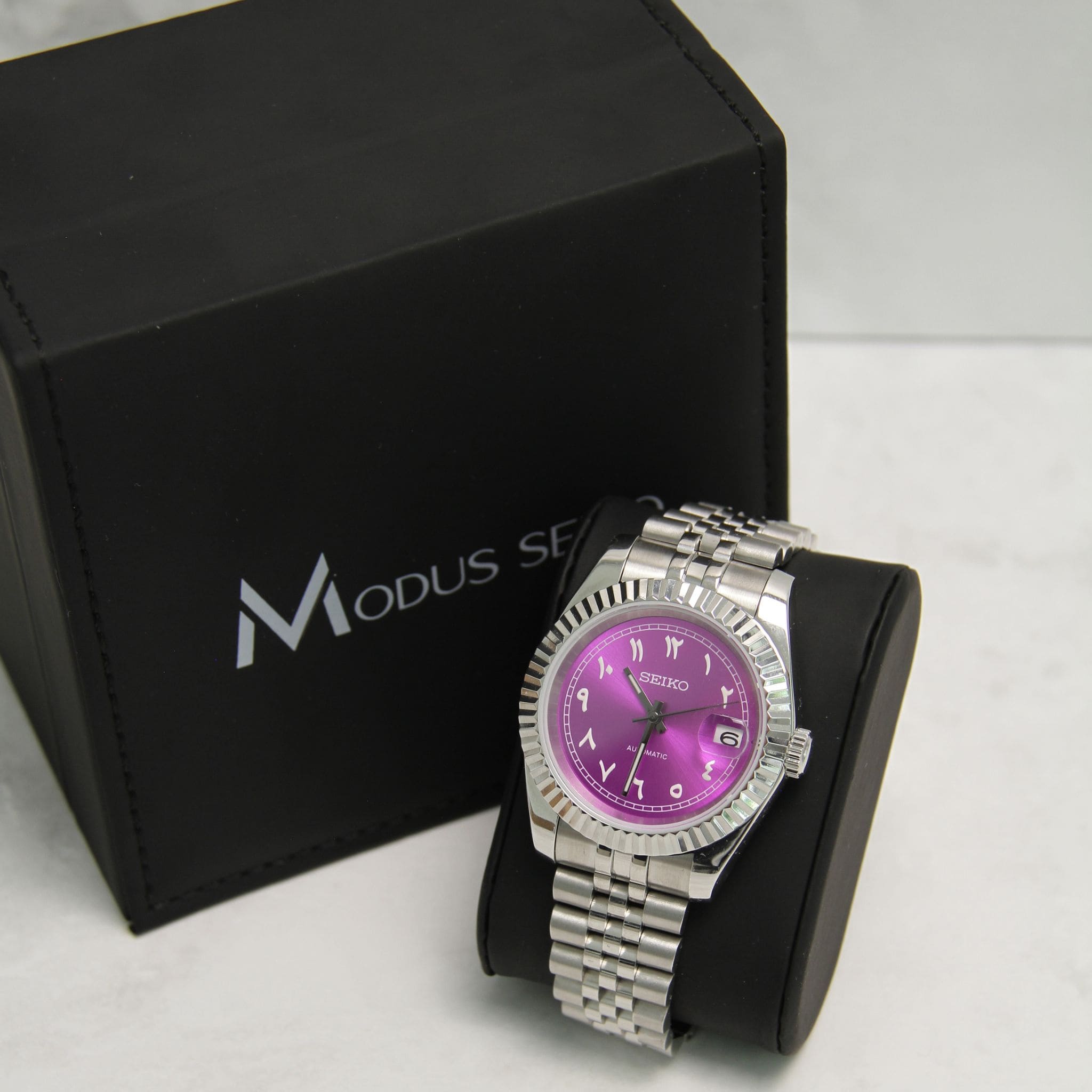 Montre Modus seiko datejust violet sur coussin noir avec écrin Modus seiko