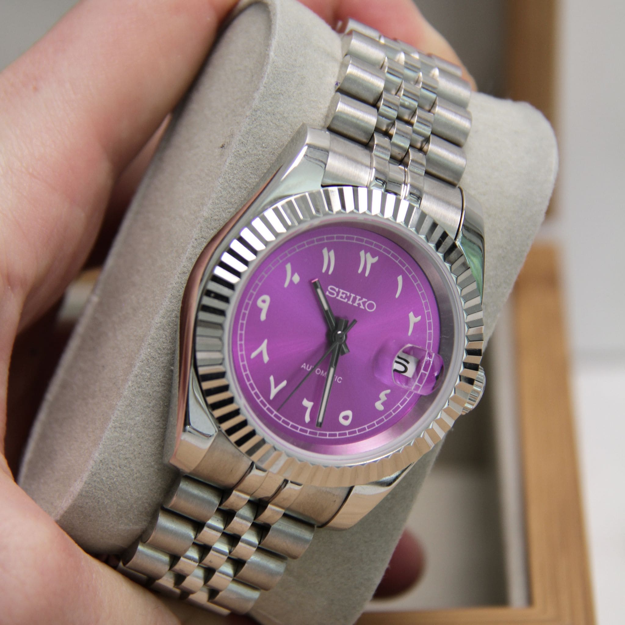 Montre Seiko mod datejust violet vu de face sur coussin